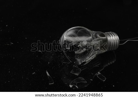 Broken light bulb on dark background
