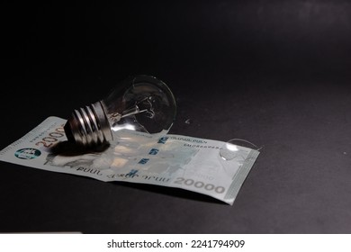 Broken light bulb with pieces of glass on Armenian dram. Concept of electricity prices and the electricity crisis in Armenia - Powered by Shutterstock