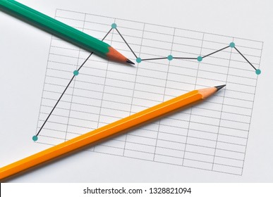 Broken line chart representing the data and two pencils on bright background