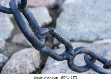 The broken link of an old rusty nautical chain.