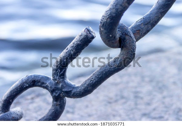 The broken\
link of an old rusty nautical\
chain.