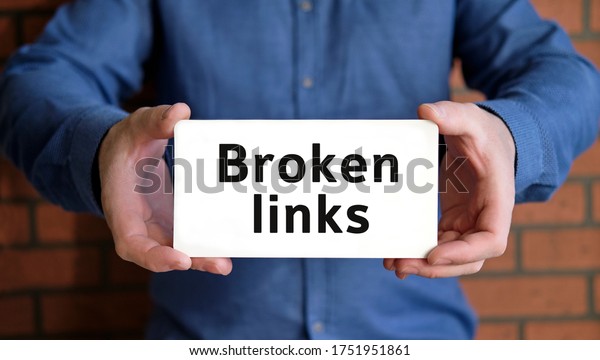 Broken links - seo concept in the hands of a young\
man in a blue shirt