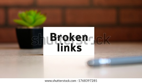 Broken links text of\
business concept on white list and with pen and a black pot with a\
flower behind