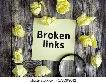Broken links - text on yellow note sheets on a dark wooden background with crumpled sheets and a magnifying glass