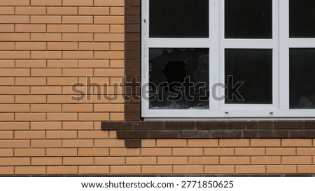A broken lower corner of a window in an uninhabited new house with dusty glass and a dark, empty interior, as a symbol of crime, theft, violence or destruction of the cottage.