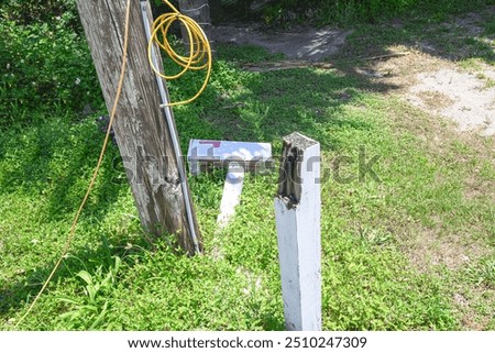 broken mailbox lying on ground coiled cable wire 4 by 4 post telephone pole