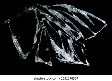 gebrochener Spiegel und Glas auf schwarzem Hintergrund in Rissen in Form einer isolierten Abstraktion