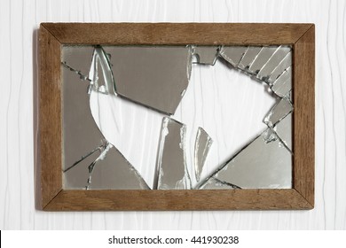 Broken mirror on white wooden