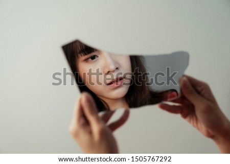 The broken mirror reflect the face of introspective Thai girl due to she lost the meaning of her life.