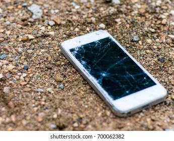 Broken Mobile Phone On Dirt Ground