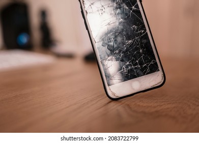 Broken Mobile Phone Screen After Fall Down. Cell Phone Damaged On The Hard Ground, Ready To Service.