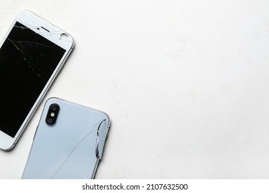 Broken mobile phones on white background, closeup