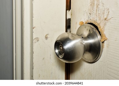 Broken modern doorknob closeup with signs of forced entry, criminal activity and door slightly open. - Shutterstock ID 2039644841