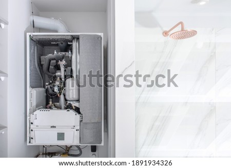 Broken Modern Water Gas Heater Next to Shower Cabin Inside Elegant Clean Bathroom Interior.