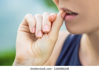 Broken Nail On A Woman's Hand With A Manicure On A Green Background. Woman Bites Nails