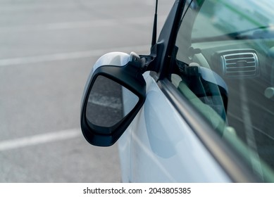 Broken off side rearview mirror on the car. White automobile on the road or in the yard after an accident. Transport damage, supermarket parking. Reflection glass crashed after collision or vandalism. - Shutterstock ID 2043805385