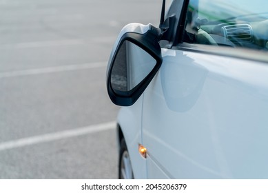 Broken off side rearview mirror on the car. White automobile on the road or in the yard after an accident. Transport damage, supermarket parking. Reflection glass crashed after collision or vandalism. - Shutterstock ID 2045206379