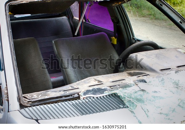 Broken old car\
with broken windshield. Close\
up.