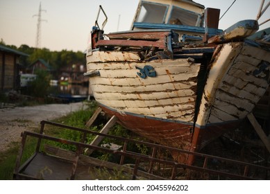 A broken old ship stranded on land serves as a monument.The beak of the deck of a broken old ship rotting on land. A romantic shot of the rotted construction of an old ship on land