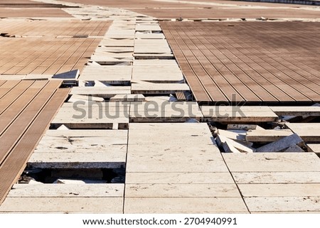 Broken paving creating an uneven surface, depicting neglect, construction issues, maintenance problems, and potential danger