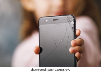 Broken Phone In Hands Of Small Child, Close-up