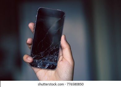 Broken phone screen in hand