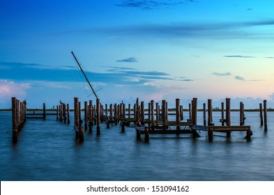 Broken pier and mast of broken ship in water after sunset in Biloxi, Mississippi
