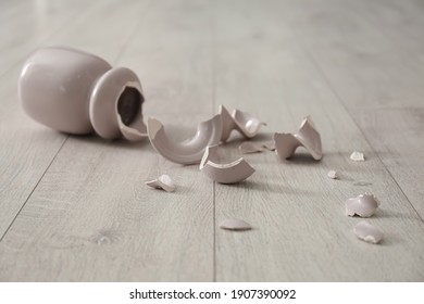 Broken Pink Ceramic Vase On Wooden Floor