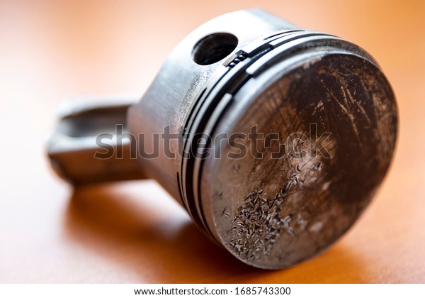 Broken piston rod with injured surface is seen in
a wooden table.