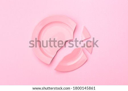 broken plate on a light background, pink toning. The concept of breaking up relations, divorce, destruction