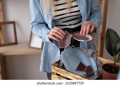 Broken Plate When Moving House In A Wooden Box, Upset Woman Holding Pieces Of Her Favorite Ceramic Tableware, Moving Problem, Relocation Concept