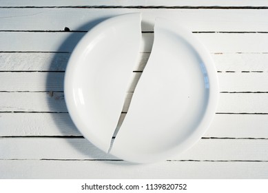 Broken Porcelain Plate On White Wooden Background