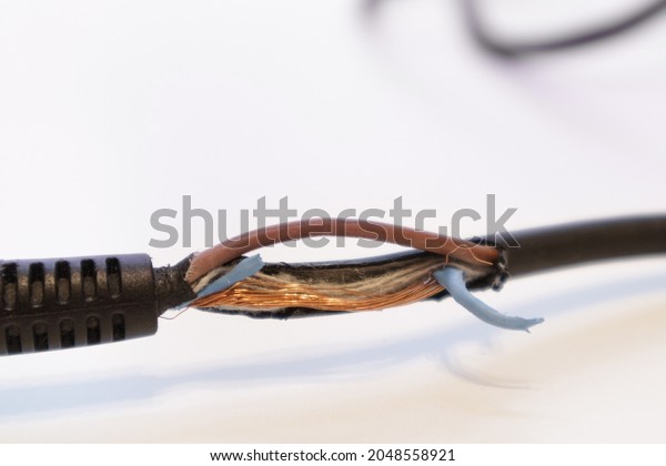 Broken power cord\
for home electrical appliances, electric tools. Damaged cable\
insulation. Close-up, soft\
focus.