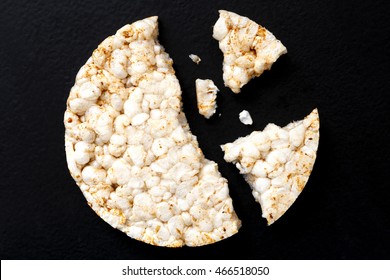 Broken Puffed Rice Cake From Above Isolated On Dark.