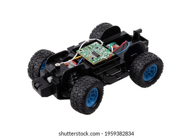 Broken radio-controlled toy car with electronic components on a white background 