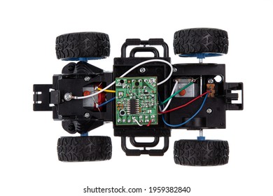 Broken radio-controlled toy car with electronic components on a white background 
