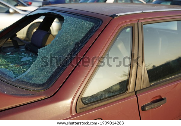 Broken rear window in
car, thief smashed window and stole valuable items in dangerous
city district concept