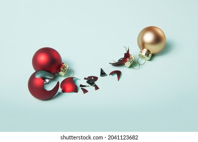 Broken Red Christmas Ball And Safe Two Christmas Ball On Light Blue Background