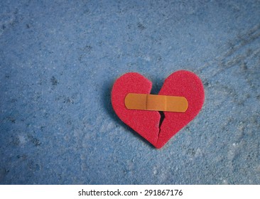 Broken Red Heart With A Bandaid, On Blue                               