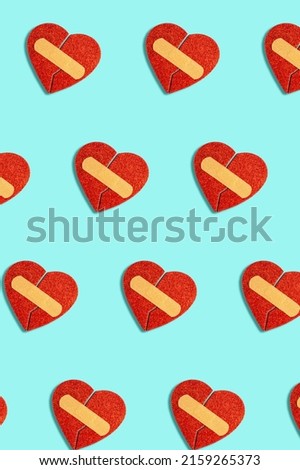 Broken red heart with medical patch on blue background. Abstract pattern, love concept