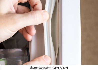 broken refrigerator door seal. appliance repair service concept. replace fridge door sealant or gasket.