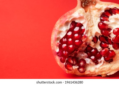 Broken ripe pomegranate fruit on a red background. juicy pomegranate berries. background.
