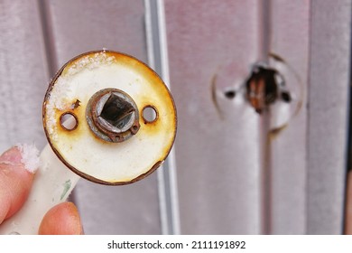 Broken Rusty Doorknob On The Background Of A Metal Door