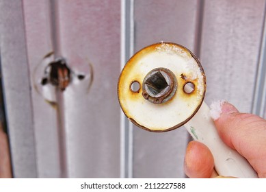 Broken Rusty Doorknob On The Background Of A Metal Door