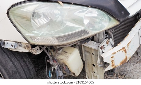 Broken Rusty White Car Bumper. Car After An Accident. Machine Repair And Parts Replacement. Street Photo. Closeup View.