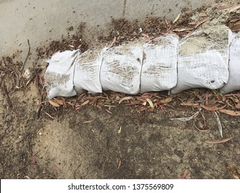 Broken Sand Bags Spilling Over Onto The Sidewalk In Fullerton, CA.