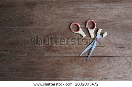Broken scissors on a wooden table.
