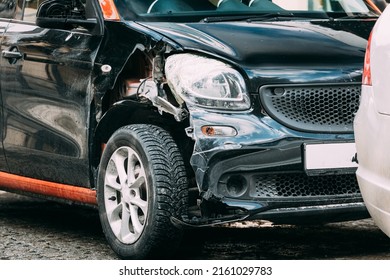 Broken Scratched And Dent Bumper Fender On Small Luxury Car After Collision. Scratched With Deep Damage To Paint. Crashed Car Parked On City Street. Car Wreck, Accident. Dent And Damage On The Car