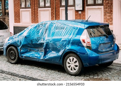 Broken Scratched And Dent Doors Side Fender Blue Car After Collision. Scratched With Deep Damage To Paint. Crashed Car Parked On City Street. Car Wreck, Accident. Dent And Damage On The Car Is Covered