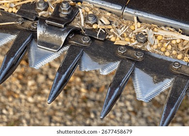 Broken sickle knife on combine harvester soybean platform.  Farm equipment maintenance, repair, and service concept